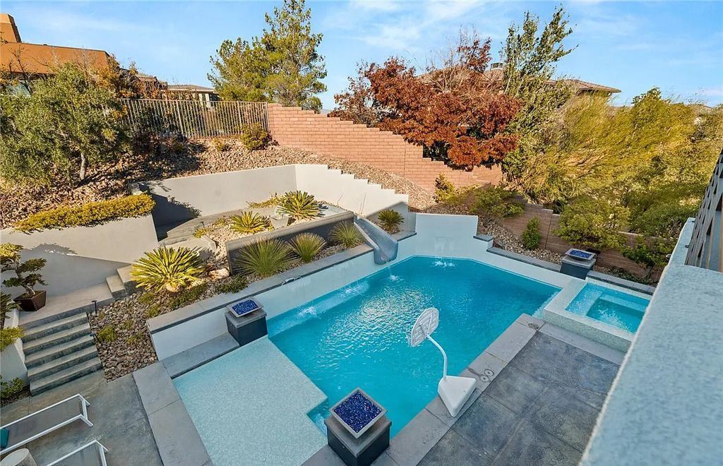 20 Skybird Court, Las Vegas, Nevada is a fully remodeled gem in the enclave of Redhawk behind the guard gates of The Ridges boasting a basketball area, pool with water slide and oversized wet deck, an indoor/outdoor bar, firepit, outdoor kitchen with ceiling mounted infrared heaters, and a wine cellar.