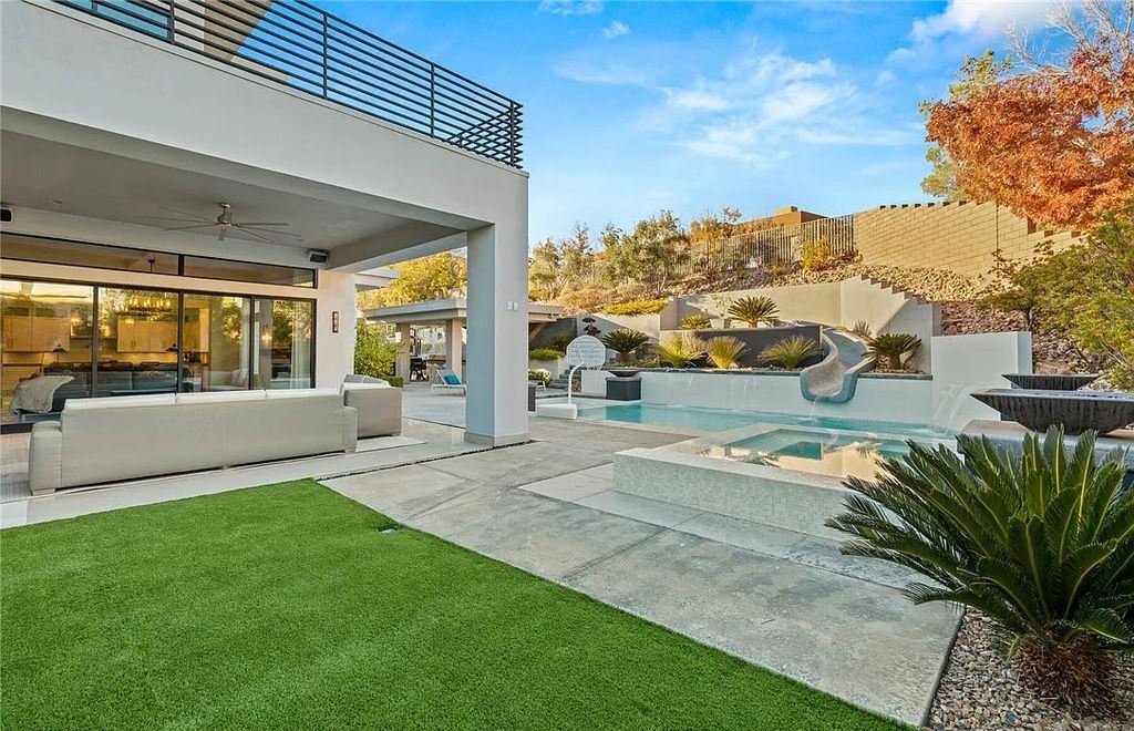 20 Skybird Court, Las Vegas, Nevada is a fully remodeled gem in the enclave of Redhawk behind the guard gates of The Ridges boasting a basketball area, pool with water slide and oversized wet deck, an indoor/outdoor bar, firepit, outdoor kitchen with ceiling mounted infrared heaters, and a wine cellar.