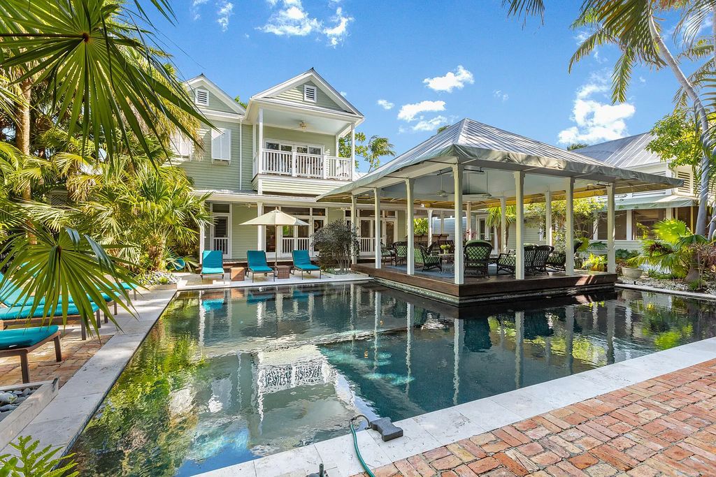 101 Admirals Lane, Key West, Florida,  provides privacy and a lush atmosphere for this remarkable home on a huge 14,000 SF lot, surrounded by a wall of tropical foliage. It is a spectacular property on one of the largest lots in the gated community of Truman Annex, featuring three separate dwellings blending traditional and contemporary architecture.