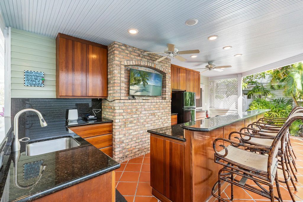 101 Admirals Lane, Key West, Florida,  provides privacy and a lush atmosphere for this remarkable home on a huge 14,000 SF lot, surrounded by a wall of tropical foliage. It is a spectacular property on one of the largest lots in the gated community of Truman Annex, featuring three separate dwellings blending traditional and contemporary architecture.