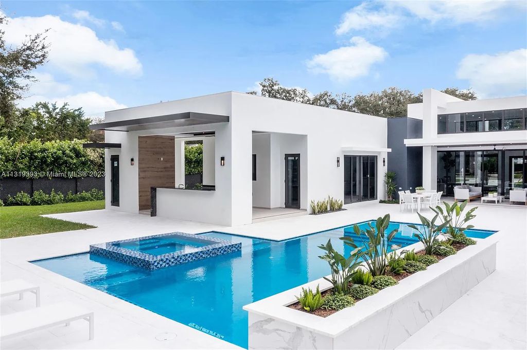 9765 SW 110th Street, Miami, Florida is an exquisite modern new construction built among stately palms and mature oak trees on a quiet cul-de-sac, experience the ultimate South Florida lifestyle lounging around the 38' pool with spa and 3 beaches.