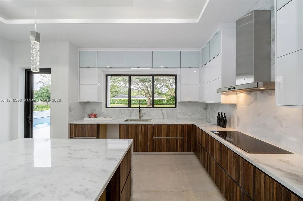 9765 SW 110th Street, Miami, Florida is an exquisite modern new construction built among stately palms and mature oak trees on a quiet cul-de-sac, experience the ultimate South Florida lifestyle lounging around the 38' pool with spa and 3 beaches.
