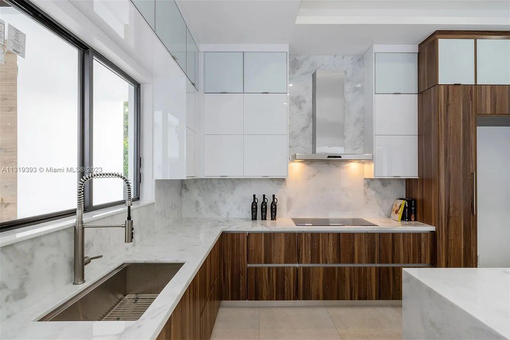9765 SW 110th Street, Miami, Florida is an exquisite modern new construction built among stately palms and mature oak trees on a quiet cul-de-sac, experience the ultimate South Florida lifestyle lounging around the 38' pool with spa and 3 beaches.