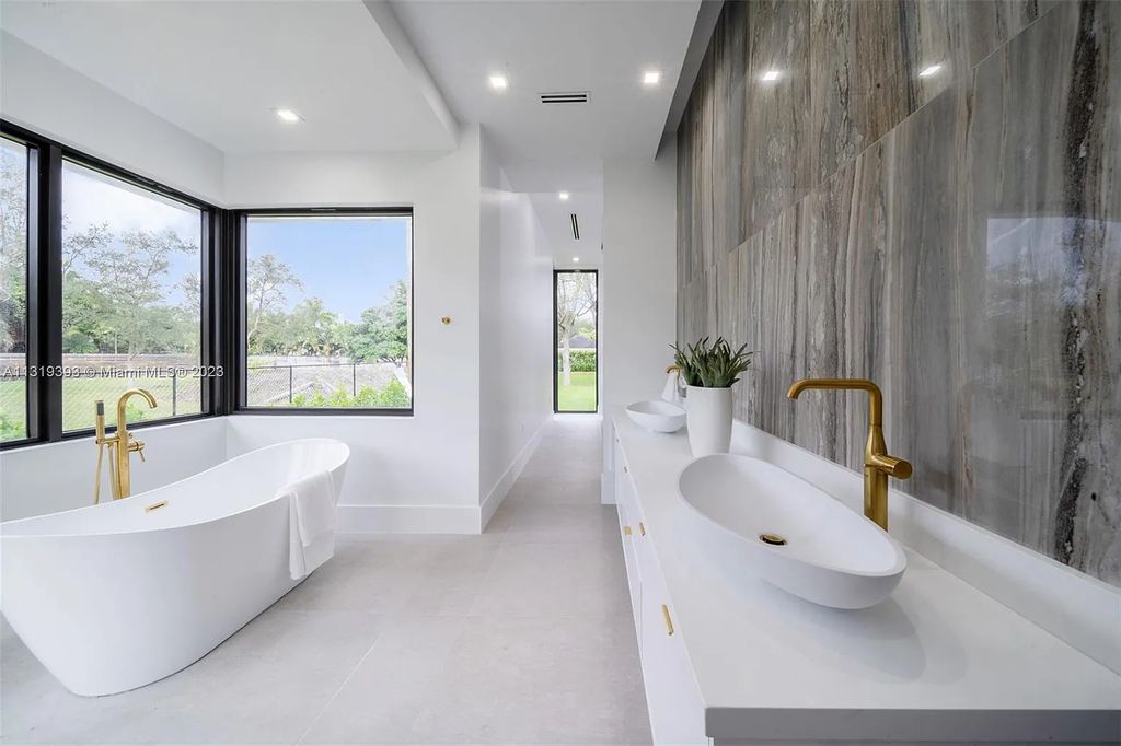 9765 SW 110th Street, Miami, Florida is an exquisite modern new construction built among stately palms and mature oak trees on a quiet cul-de-sac, experience the ultimate South Florida lifestyle lounging around the 38' pool with spa and 3 beaches.