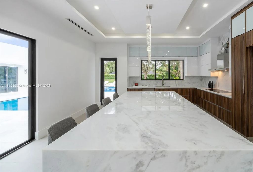 9765 SW 110th Street, Miami, Florida is an exquisite modern new construction built among stately palms and mature oak trees on a quiet cul-de-sac, experience the ultimate South Florida lifestyle lounging around the 38' pool with spa and 3 beaches.
