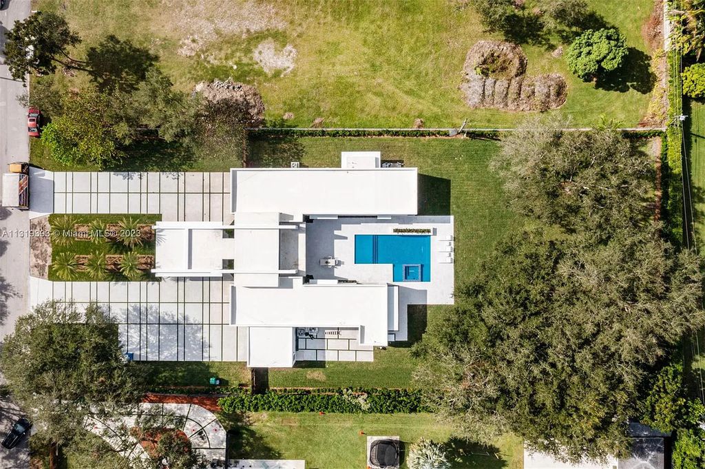 9765 SW 110th Street, Miami, Florida is an exquisite modern new construction built among stately palms and mature oak trees on a quiet cul-de-sac, experience the ultimate South Florida lifestyle lounging around the 38' pool with spa and 3 beaches.
