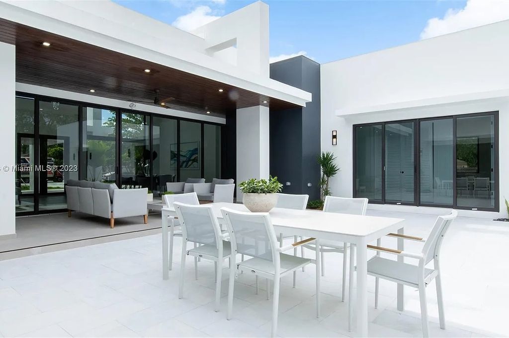 9765 SW 110th Street, Miami, Florida is an exquisite modern new construction built among stately palms and mature oak trees on a quiet cul-de-sac, experience the ultimate South Florida lifestyle lounging around the 38' pool with spa and 3 beaches.