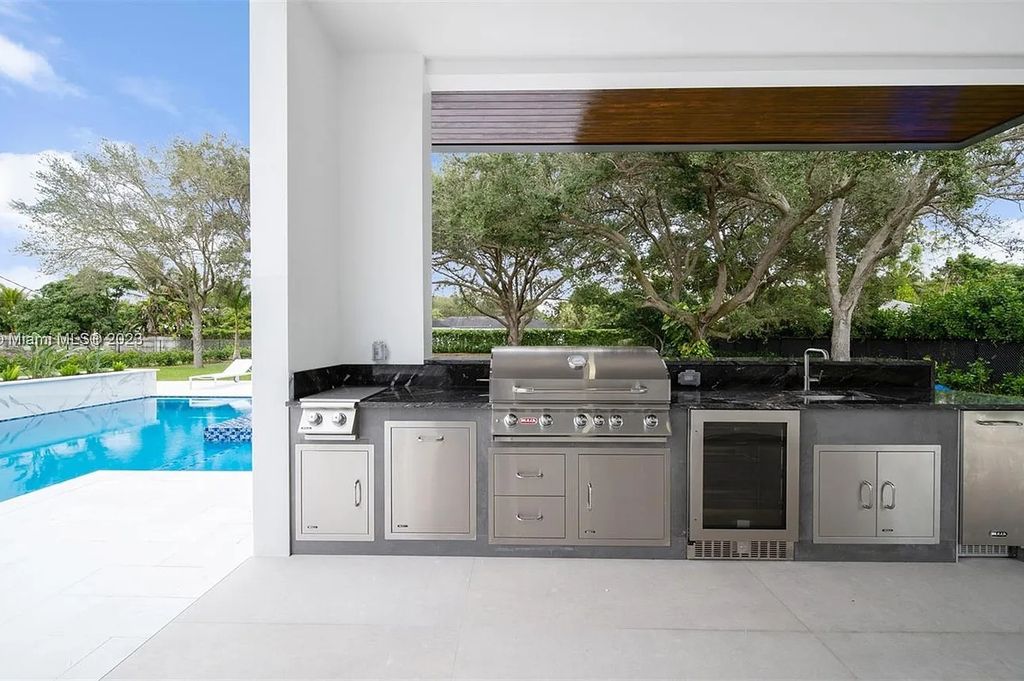 9765 SW 110th Street, Miami, Florida is an exquisite modern new construction built among stately palms and mature oak trees on a quiet cul-de-sac, experience the ultimate South Florida lifestyle lounging around the 38' pool with spa and 3 beaches.