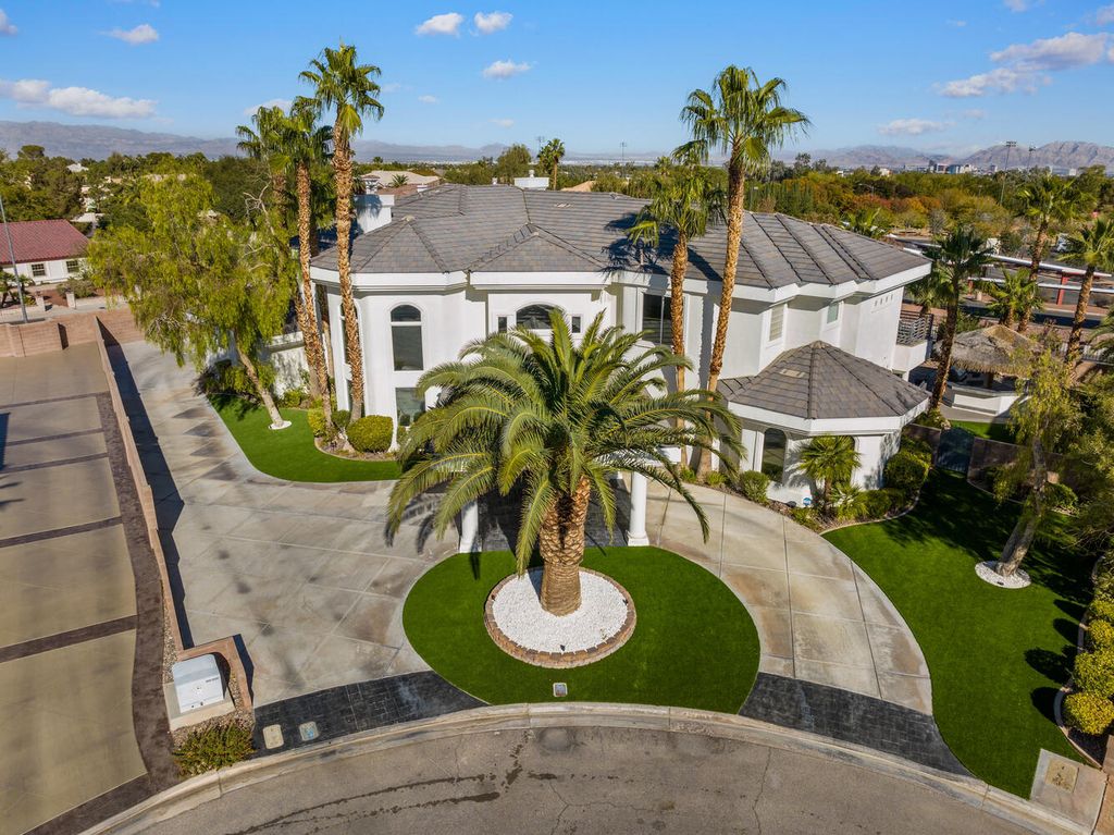 2000 Bogart Court, Las Vegas, Nevada is a one of a kind home situated on a cul-de-sac inside a private gated community featuring stunning finishes throughout with Limestone and hardwood flooring, quartzite fireplace, motorized window shades and grand 24” foot ceilings.