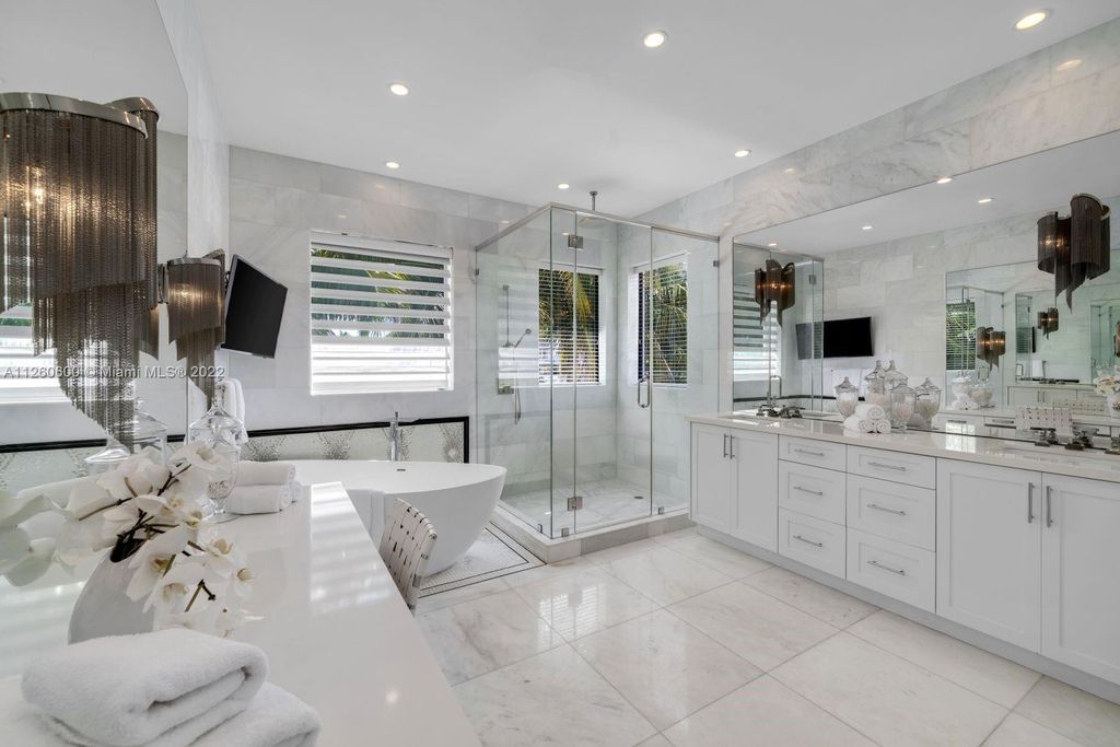 2901 Flamingo Drive, Miami Beach, Florida is named La Joya with 300 foot of water in most vibrant neighborhood on Miami Beach, features include dramatic master + sitting rm. 13ft ceilings, wall of glass, + 3 terraces. 4 beds up 1 down+ office/library. 1 bd, 1 and a half bath guest villa with private patio, 2 car garage, private gated entry court.