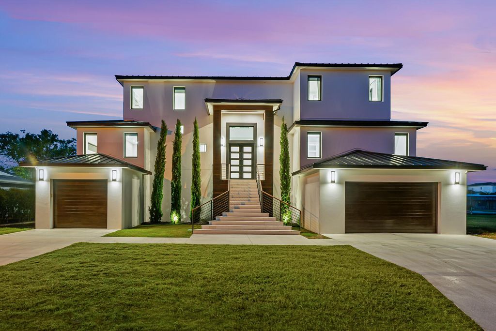 545 Kingfisher Lane, Longboat Key, Florida is a custom built modern canal front Longboat Key home with dramatic wide shell stone stair entrance, massive 60-inch ceramic tile flooring, 20-foot ceilings, skylights, lap-pool with 2 waterfall features, outdoor kitchen adjacent to indoor kitchen, and 5-car garage.