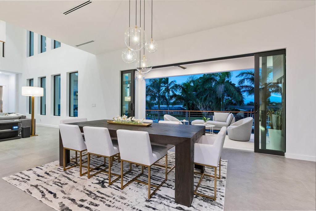 545 Kingfisher Lane, Longboat Key, Florida is a custom built modern canal front Longboat Key home with dramatic wide shell stone stair entrance, massive 60-inch ceramic tile flooring, 20-foot ceilings, skylights, lap-pool with 2 waterfall features, outdoor kitchen adjacent to indoor kitchen, and 5-car garage.