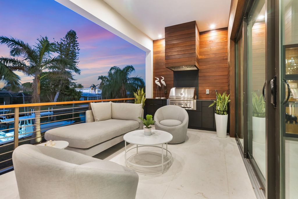 545 Kingfisher Lane, Longboat Key, Florida is a custom built modern canal front Longboat Key home with dramatic wide shell stone stair entrance, massive 60-inch ceramic tile flooring, 20-foot ceilings, skylights, lap-pool with 2 waterfall features, outdoor kitchen adjacent to indoor kitchen, and 5-car garage.