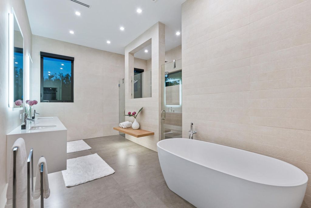 545 Kingfisher Lane, Longboat Key, Florida is a custom built modern canal front Longboat Key home with dramatic wide shell stone stair entrance, massive 60-inch ceramic tile flooring, 20-foot ceilings, skylights, lap-pool with 2 waterfall features, outdoor kitchen adjacent to indoor kitchen, and 5-car garage.