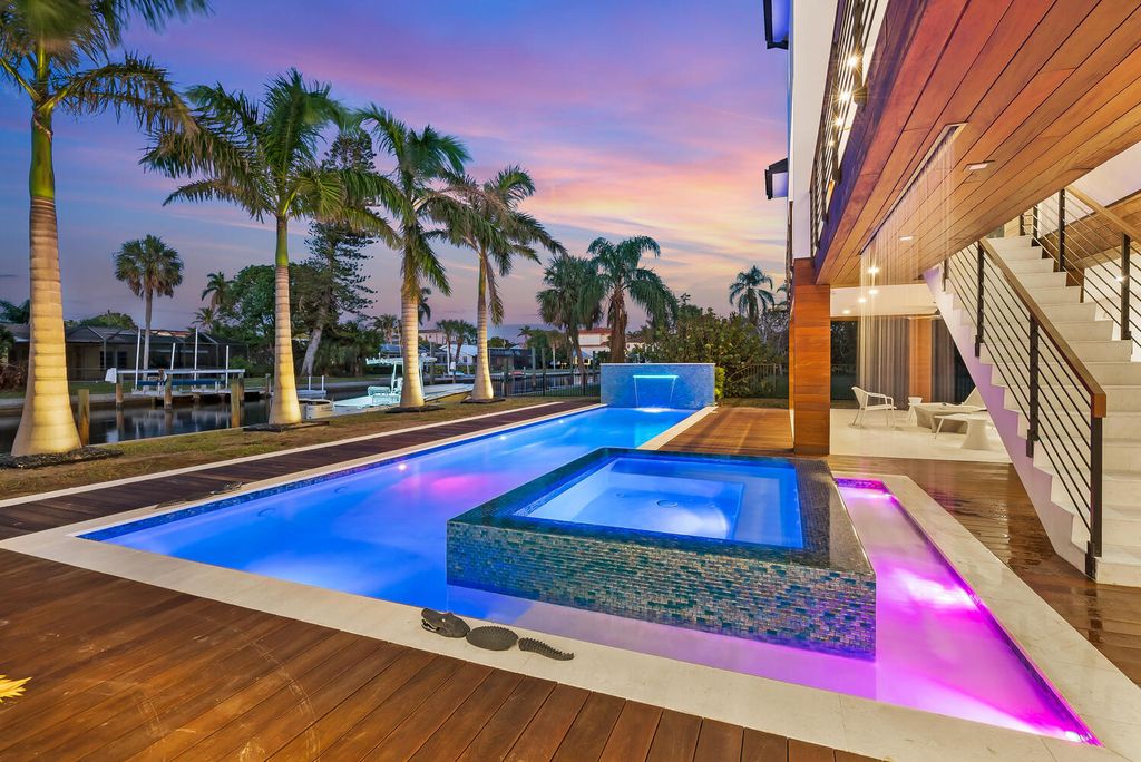 545 Kingfisher Lane, Longboat Key, Florida is a custom built modern canal front Longboat Key home with dramatic wide shell stone stair entrance, massive 60-inch ceramic tile flooring, 20-foot ceilings, skylights, lap-pool with 2 waterfall features, outdoor kitchen adjacent to indoor kitchen, and 5-car garage.