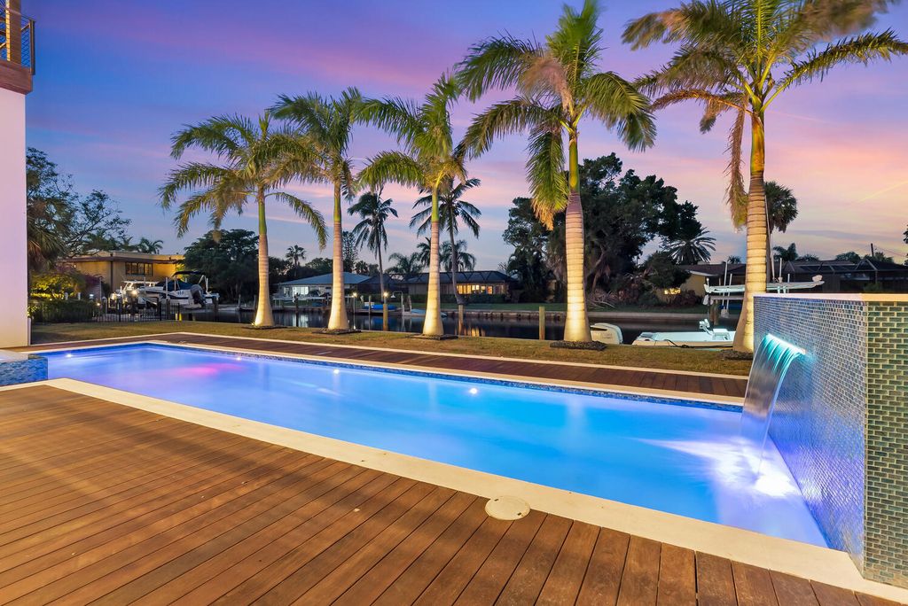 545 Kingfisher Lane, Longboat Key, Florida is a custom built modern canal front Longboat Key home with dramatic wide shell stone stair entrance, massive 60-inch ceramic tile flooring, 20-foot ceilings, skylights, lap-pool with 2 waterfall features, outdoor kitchen adjacent to indoor kitchen, and 5-car garage.