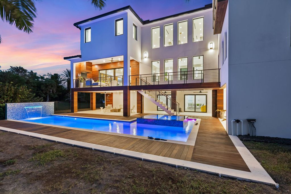 545 Kingfisher Lane, Longboat Key, Florida is a custom built modern canal front Longboat Key home with dramatic wide shell stone stair entrance, massive 60-inch ceramic tile flooring, 20-foot ceilings, skylights, lap-pool with 2 waterfall features, outdoor kitchen adjacent to indoor kitchen, and 5-car garage.