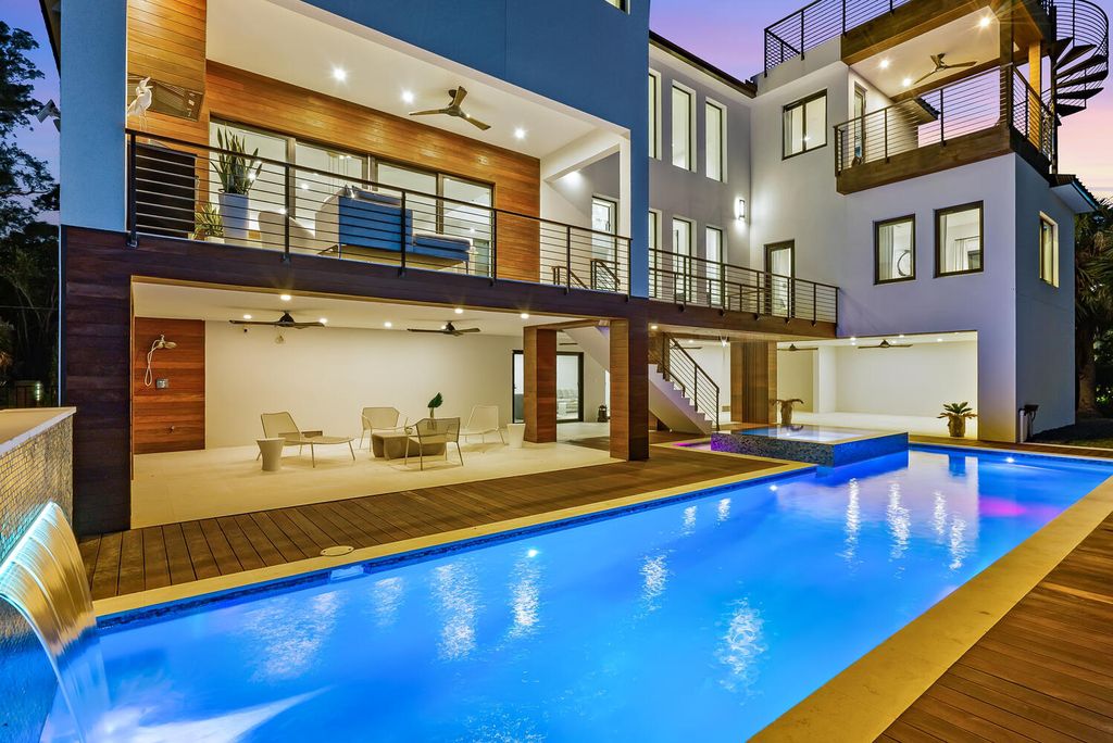 545 Kingfisher Lane, Longboat Key, Florida is a custom built modern canal front Longboat Key home with dramatic wide shell stone stair entrance, massive 60-inch ceramic tile flooring, 20-foot ceilings, skylights, lap-pool with 2 waterfall features, outdoor kitchen adjacent to indoor kitchen, and 5-car garage.