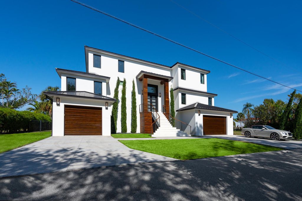 545 Kingfisher Lane, Longboat Key, Florida is a custom built modern canal front Longboat Key home with dramatic wide shell stone stair entrance, massive 60-inch ceramic tile flooring, 20-foot ceilings, skylights, lap-pool with 2 waterfall features, outdoor kitchen adjacent to indoor kitchen, and 5-car garage.