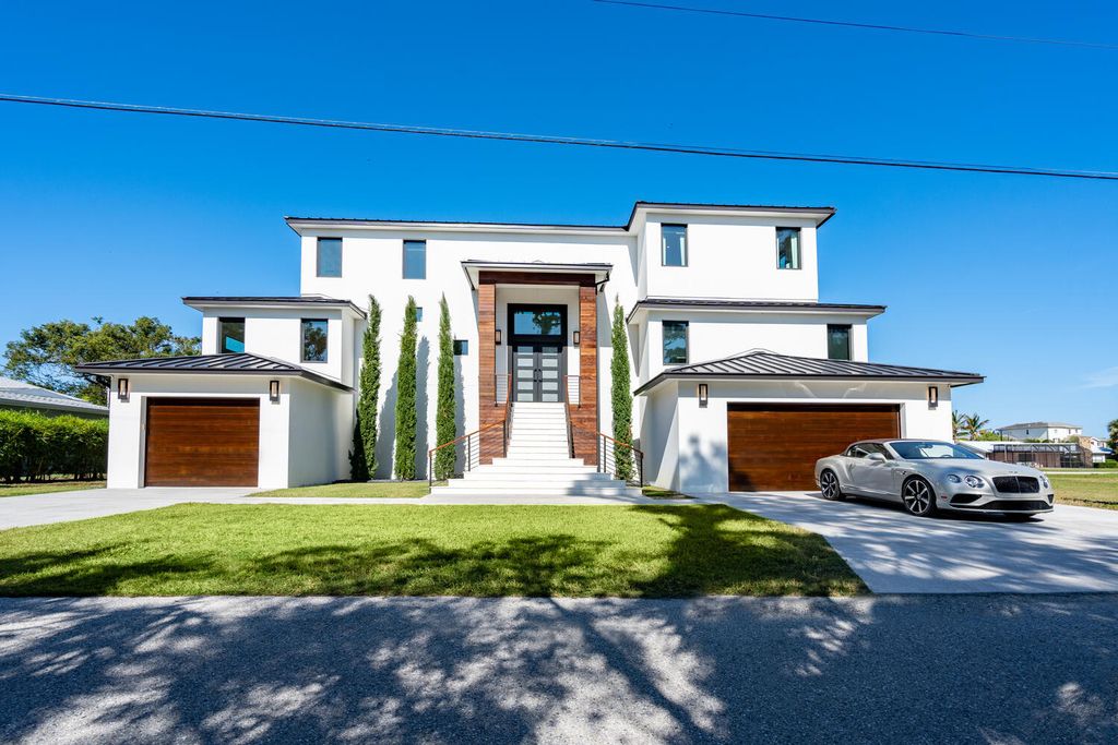 545 Kingfisher Lane, Longboat Key, Florida is a custom built modern canal front Longboat Key home with dramatic wide shell stone stair entrance, massive 60-inch ceramic tile flooring, 20-foot ceilings, skylights, lap-pool with 2 waterfall features, outdoor kitchen adjacent to indoor kitchen, and 5-car garage.