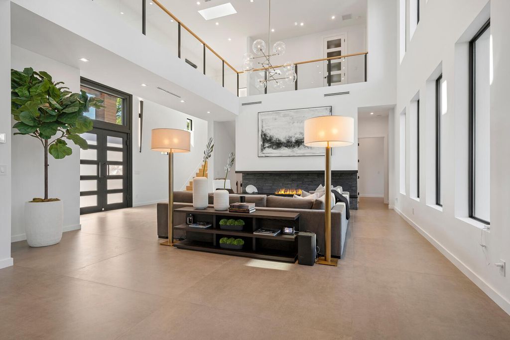 545 Kingfisher Lane, Longboat Key, Florida is a custom built modern canal front Longboat Key home with dramatic wide shell stone stair entrance, massive 60-inch ceramic tile flooring, 20-foot ceilings, skylights, lap-pool with 2 waterfall features, outdoor kitchen adjacent to indoor kitchen, and 5-car garage.