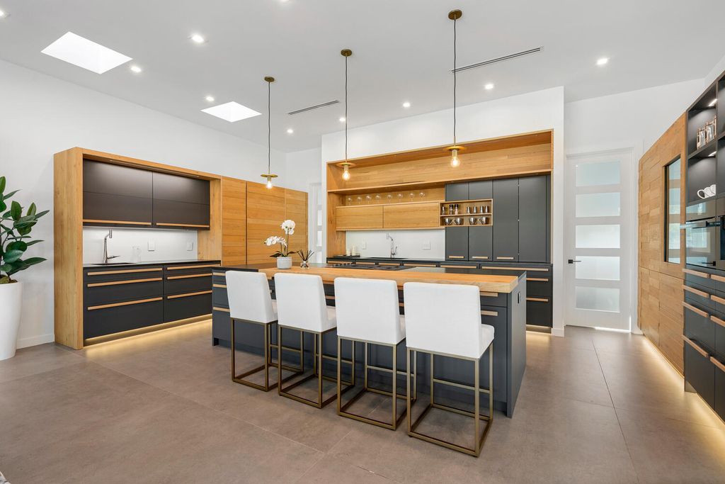 545 Kingfisher Lane, Longboat Key, Florida is a custom built modern canal front Longboat Key home with dramatic wide shell stone stair entrance, massive 60-inch ceramic tile flooring, 20-foot ceilings, skylights, lap-pool with 2 waterfall features, outdoor kitchen adjacent to indoor kitchen, and 5-car garage.