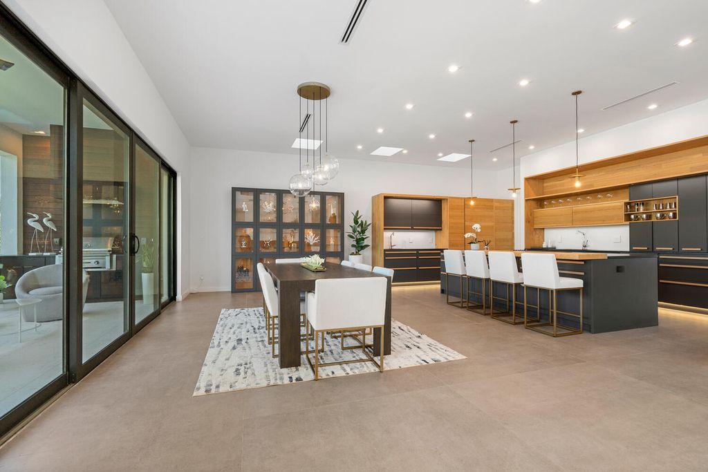545 Kingfisher Lane, Longboat Key, Florida is a custom built modern canal front Longboat Key home with dramatic wide shell stone stair entrance, massive 60-inch ceramic tile flooring, 20-foot ceilings, skylights, lap-pool with 2 waterfall features, outdoor kitchen adjacent to indoor kitchen, and 5-car garage.