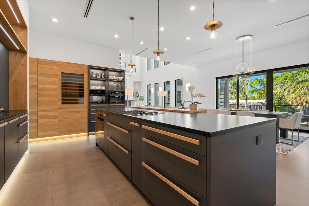 545 Kingfisher Lane, Longboat Key, Florida is a custom built modern canal front Longboat Key home with dramatic wide shell stone stair entrance, massive 60-inch ceramic tile flooring, 20-foot ceilings, skylights, lap-pool with 2 waterfall features, outdoor kitchen adjacent to indoor kitchen, and 5-car garage.