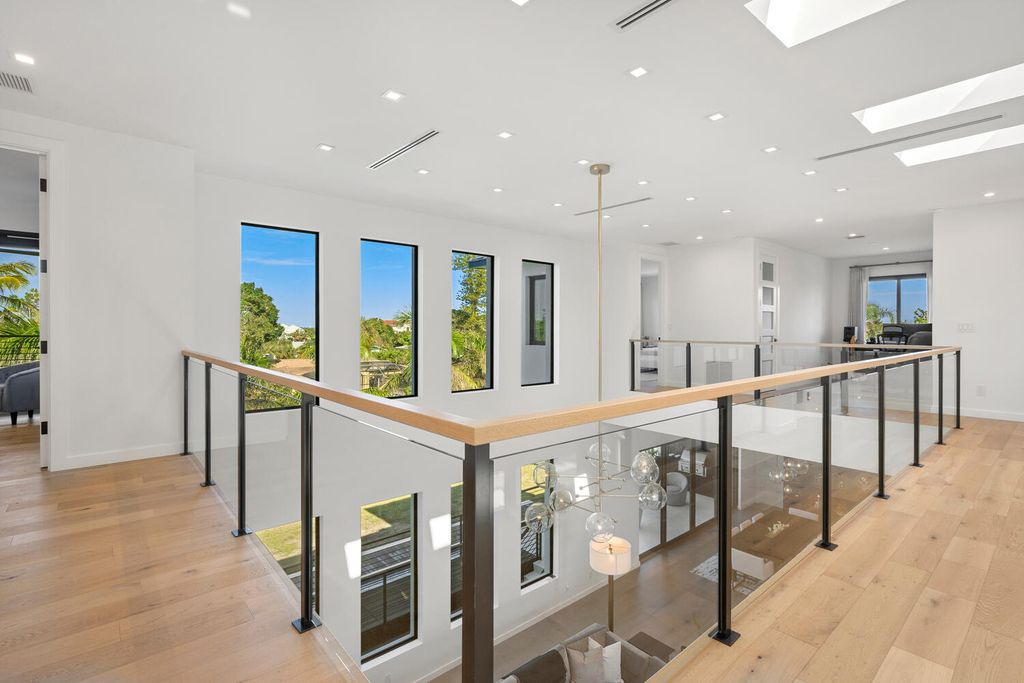 545 Kingfisher Lane, Longboat Key, Florida is a custom built modern canal front Longboat Key home with dramatic wide shell stone stair entrance, massive 60-inch ceramic tile flooring, 20-foot ceilings, skylights, lap-pool with 2 waterfall features, outdoor kitchen adjacent to indoor kitchen, and 5-car garage.
