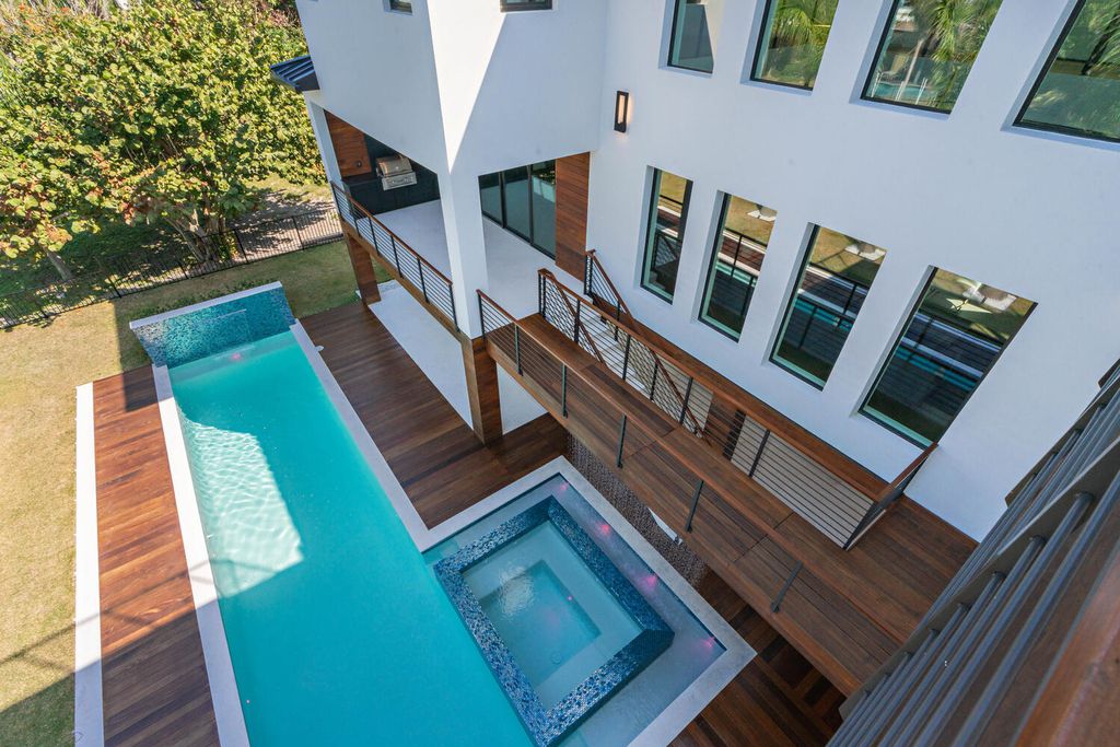 545 Kingfisher Lane, Longboat Key, Florida is a custom built modern canal front Longboat Key home with dramatic wide shell stone stair entrance, massive 60-inch ceramic tile flooring, 20-foot ceilings, skylights, lap-pool with 2 waterfall features, outdoor kitchen adjacent to indoor kitchen, and 5-car garage.