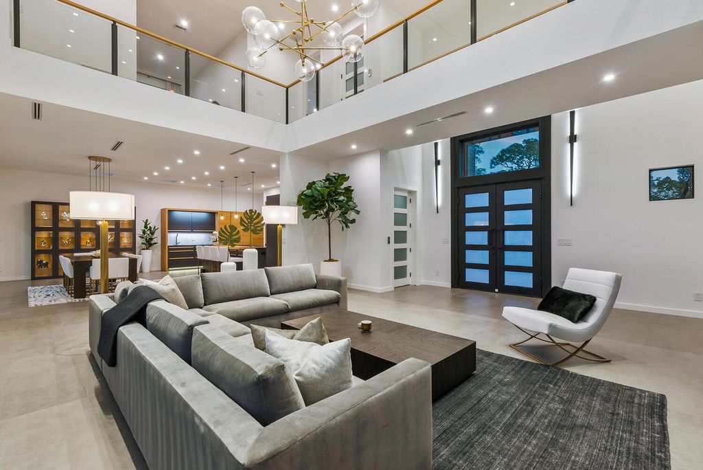 545 Kingfisher Lane, Longboat Key, Florida is a custom built modern canal front Longboat Key home with dramatic wide shell stone stair entrance, massive 60-inch ceramic tile flooring, 20-foot ceilings, skylights, lap-pool with 2 waterfall features, outdoor kitchen adjacent to indoor kitchen, and 5-car garage.