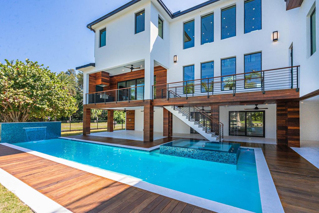 545 Kingfisher Lane, Longboat Key, Florida is a custom built modern canal front Longboat Key home with dramatic wide shell stone stair entrance, massive 60-inch ceramic tile flooring, 20-foot ceilings, skylights, lap-pool with 2 waterfall features, outdoor kitchen adjacent to indoor kitchen, and 5-car garage.