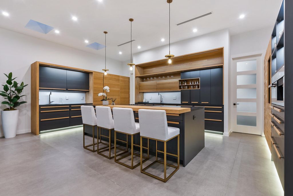 545 Kingfisher Lane, Longboat Key, Florida is a custom built modern canal front Longboat Key home with dramatic wide shell stone stair entrance, massive 60-inch ceramic tile flooring, 20-foot ceilings, skylights, lap-pool with 2 waterfall features, outdoor kitchen adjacent to indoor kitchen, and 5-car garage.