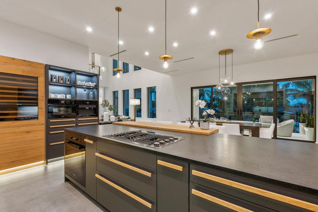 545 Kingfisher Lane, Longboat Key, Florida is a custom built modern canal front Longboat Key home with dramatic wide shell stone stair entrance, massive 60-inch ceramic tile flooring, 20-foot ceilings, skylights, lap-pool with 2 waterfall features, outdoor kitchen adjacent to indoor kitchen, and 5-car garage.