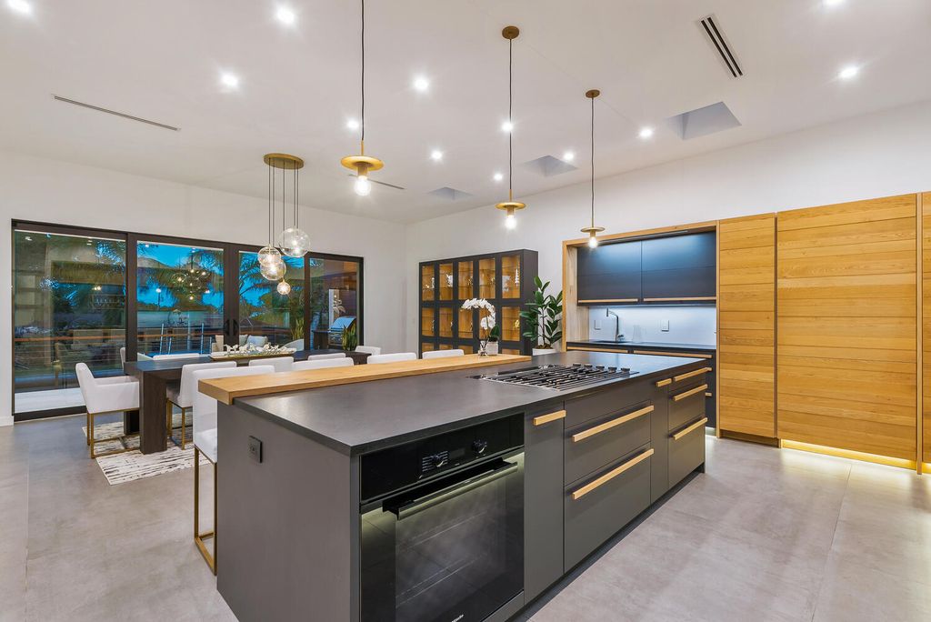 545 Kingfisher Lane, Longboat Key, Florida is a custom built modern canal front Longboat Key home with dramatic wide shell stone stair entrance, massive 60-inch ceramic tile flooring, 20-foot ceilings, skylights, lap-pool with 2 waterfall features, outdoor kitchen adjacent to indoor kitchen, and 5-car garage.