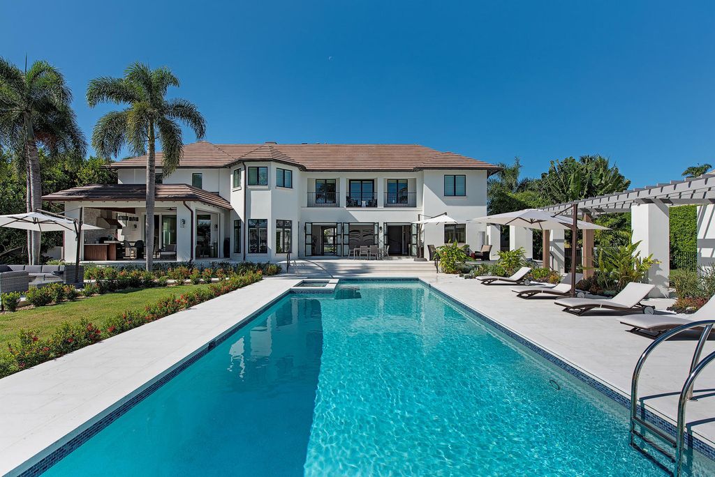 3595 Gin Lane, Naples, Florida is a gated property situated on nearly an acre overlooking Hidden Bay with quick access to the Gulf of Mexico, beautifully renovated and reimagined in 2018 with amenities as a private elevator, cherry wood library, double island in kitchen. 