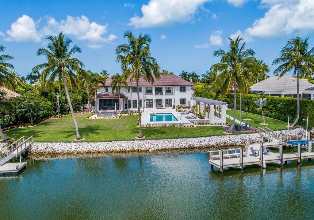 3595 Gin Lane, Naples, Florida is a gated property situated on nearly an acre overlooking Hidden Bay with quick access to the Gulf of Mexico, beautifully renovated and reimagined in 2018 with amenities as a private elevator, cherry wood library, double island in kitchen. 