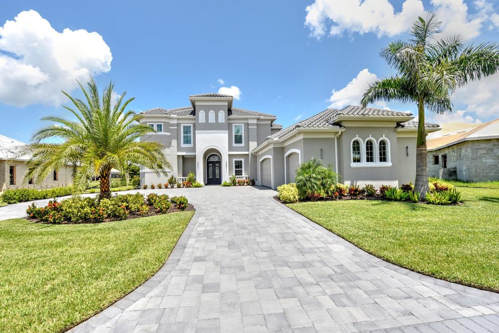 13335 Whispering Oaks Drive, Fort Myers, Florida is a custom built home by Royal Corinthian Homes in the highly sought-after luxury golf community Verandah with oversized tile throughout, custom cabinets including paneled refrigerator, thermidor appliance package, quartz kitchen countertops, interior mezzanine balcony, dual master suites.