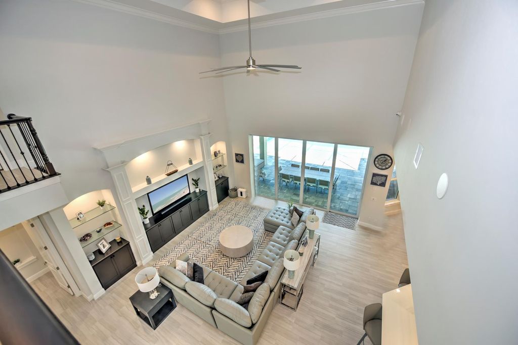 13335 Whispering Oaks Drive, Fort Myers, Florida is a custom built home by Royal Corinthian Homes in the highly sought-after luxury golf community Verandah with oversized tile throughout, custom cabinets including paneled refrigerator, thermidor appliance package, quartz kitchen countertops, interior mezzanine balcony, dual master suites.