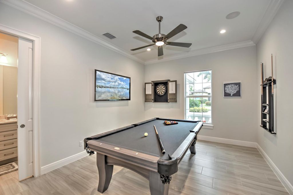 13335 Whispering Oaks Drive, Fort Myers, Florida is a custom built home by Royal Corinthian Homes in the highly sought-after luxury golf community Verandah with oversized tile throughout, custom cabinets including paneled refrigerator, thermidor appliance package, quartz kitchen countertops, interior mezzanine balcony, dual master suites.