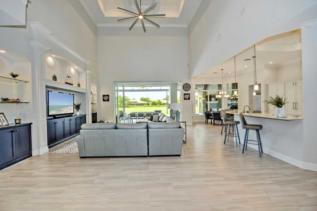 13335 Whispering Oaks Drive, Fort Myers, Florida is a custom built home by Royal Corinthian Homes in the highly sought-after luxury golf community Verandah with oversized tile throughout, custom cabinets including paneled refrigerator, thermidor appliance package, quartz kitchen countertops, interior mezzanine balcony, dual master suites.