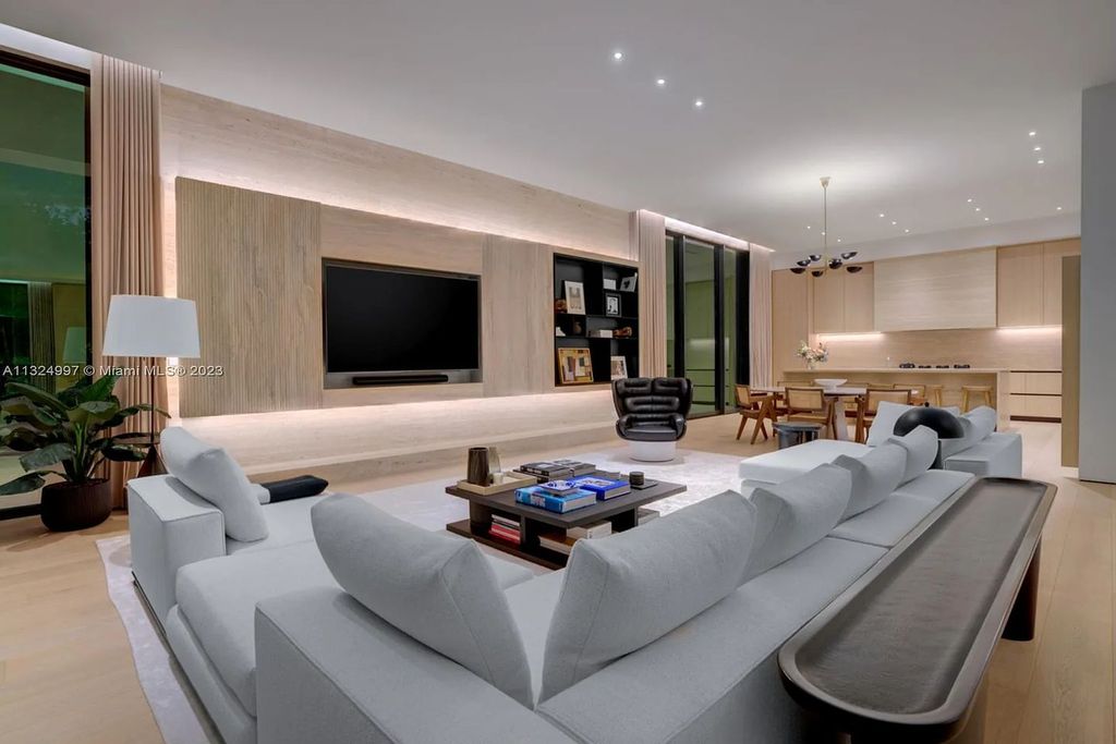 28 W Di Lido Drive, Miami Beach, Florida is stunning home where relaxed island living meets worldly sophistication, incredible features include 12ft ceilings, column-free living, 54ft of automated glass, media bookshelf, wine bar, & vapor fireplace highlight the textured travertine and white oak palette.
