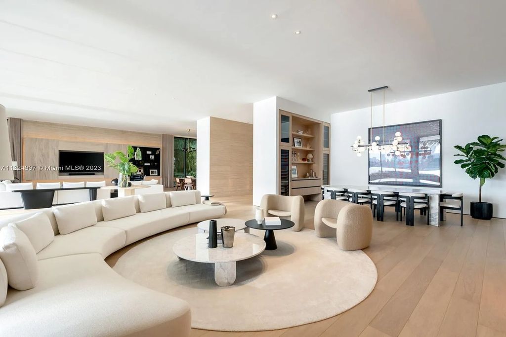 28 W Di Lido Drive, Miami Beach, Florida is stunning home where relaxed island living meets worldly sophistication, incredible features include 12ft ceilings, column-free living, 54ft of automated glass, media bookshelf, wine bar, & vapor fireplace highlight the textured travertine and white oak palette.