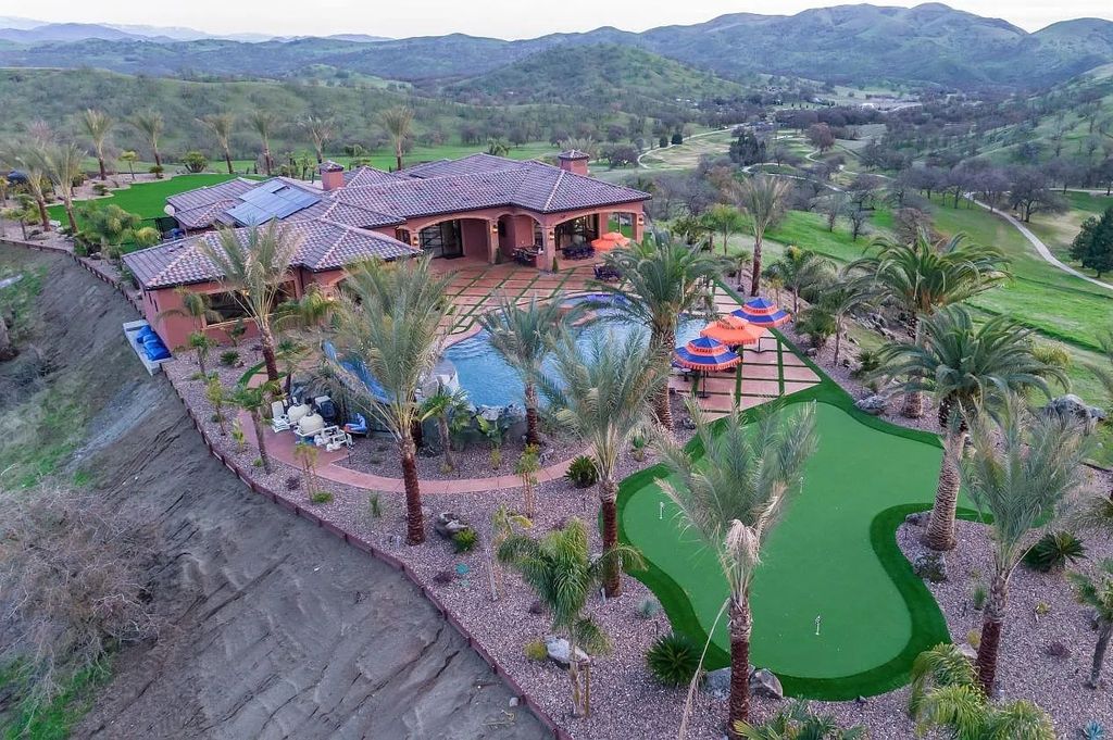 22137 Oak Glen Lane, Friant, California is a newly constructed home boasts 360 degree views of the snow-capped Sierras, Millerton Lake, Eagle Springs Golf Course and the City, enjoying the massive resort-style pool which includes a waterslide, private grotto and recessed fire pit.