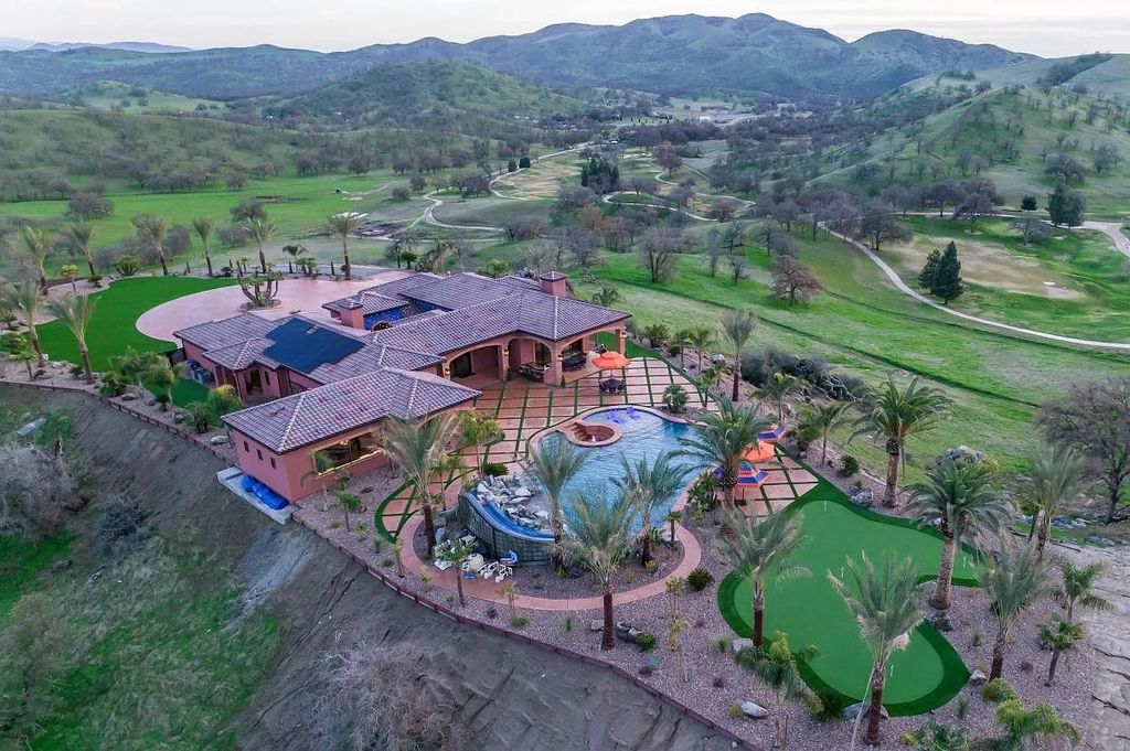 22137 Oak Glen Lane, Friant, California is a newly constructed home boasts 360 degree views of the snow-capped Sierras, Millerton Lake, Eagle Springs Golf Course and the City, enjoying the massive resort-style pool which includes a waterslide, private grotto and recessed fire pit.