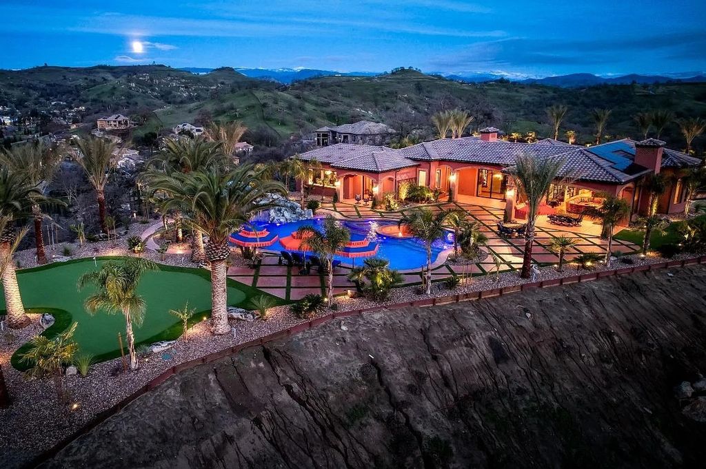 22137 Oak Glen Lane, Friant, California is a newly constructed home boasts 360 degree views of the snow-capped Sierras, Millerton Lake, Eagle Springs Golf Course and the City, enjoying the massive resort-style pool which includes a waterslide, private grotto and recessed fire pit.
