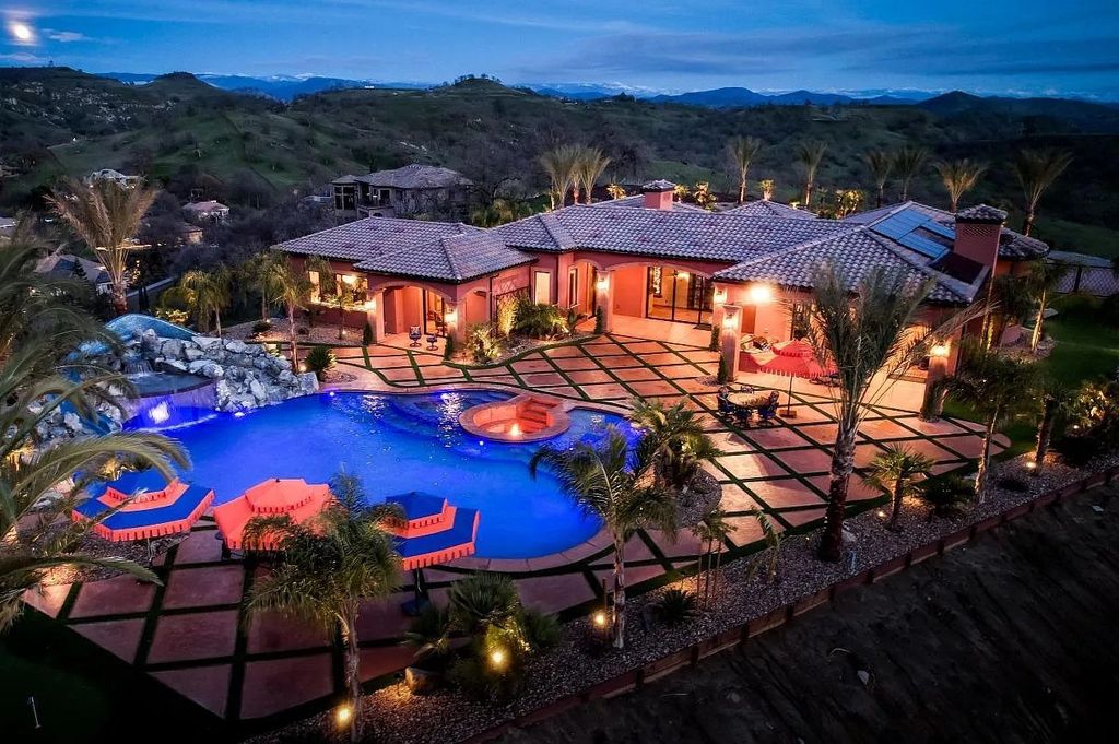 22137 Oak Glen Lane, Friant, California is a newly constructed home boasts 360 degree views of the snow-capped Sierras, Millerton Lake, Eagle Springs Golf Course and the City, enjoying the massive resort-style pool which includes a waterslide, private grotto and recessed fire pit.