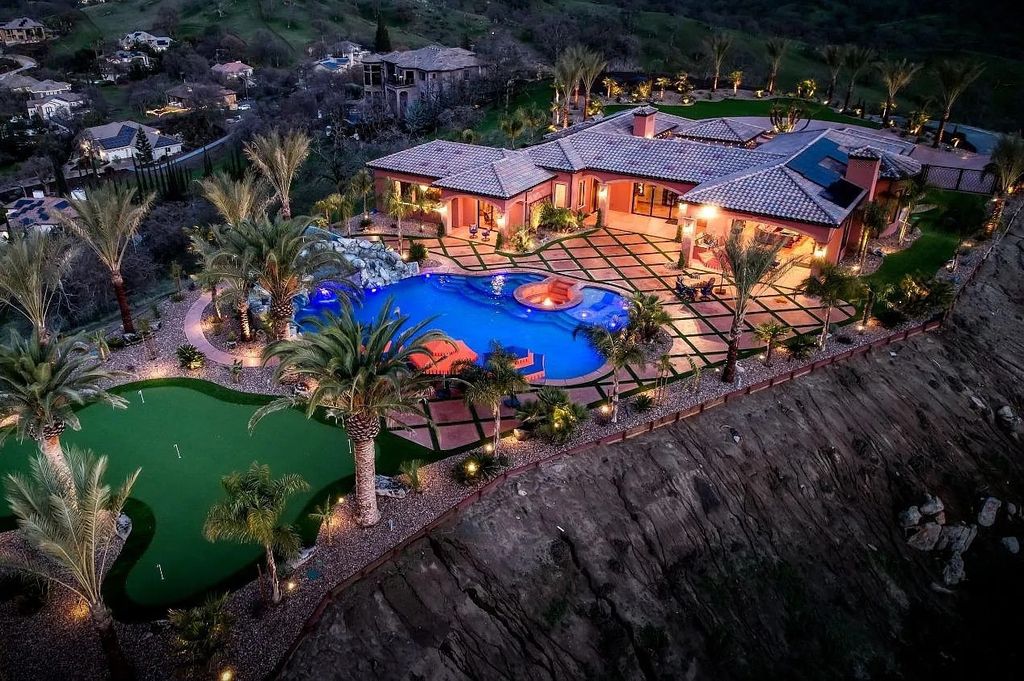 22137 Oak Glen Lane, Friant, California is a newly constructed home boasts 360 degree views of the snow-capped Sierras, Millerton Lake, Eagle Springs Golf Course and the City, enjoying the massive resort-style pool which includes a waterslide, private grotto and recessed fire pit.