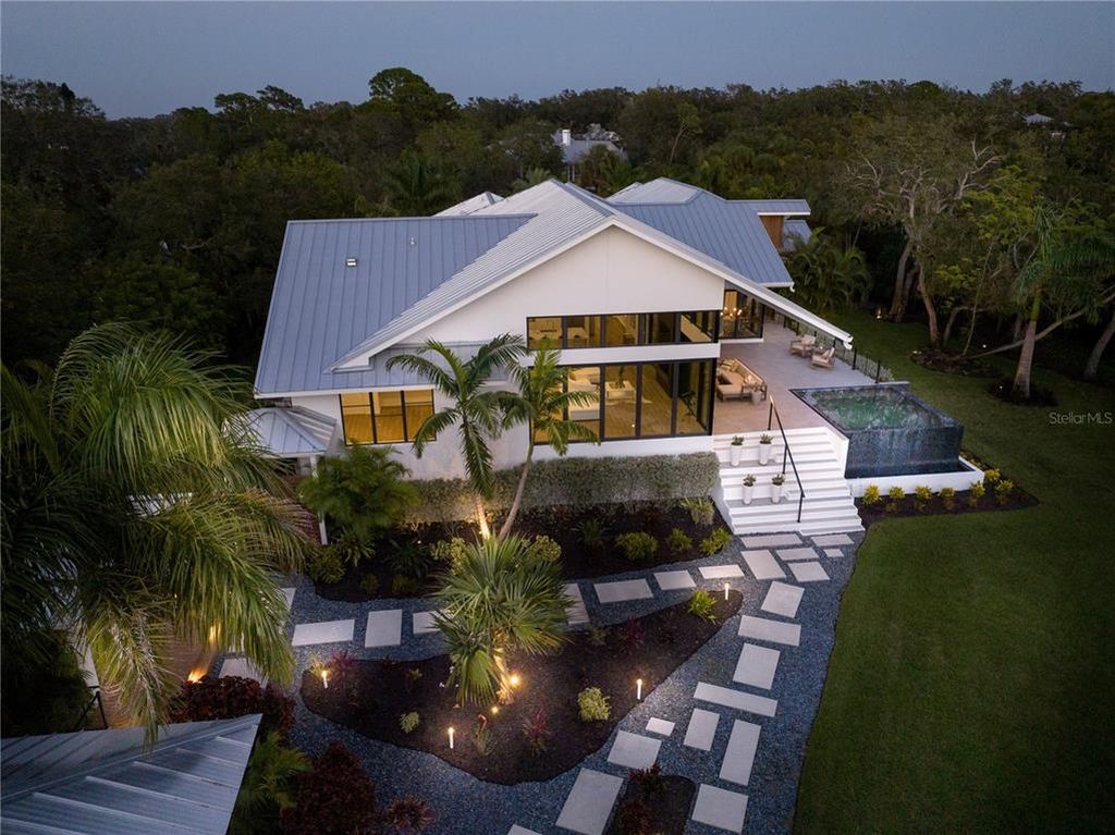 3940 Elysian Woods Lane, Sarasota, Florida is a mature landscaped estate is nestled on 1.47 acres and completely private in a small, gated community with only eight homes, was built with meticulous craftsmanship and bespoke finishes throughout.