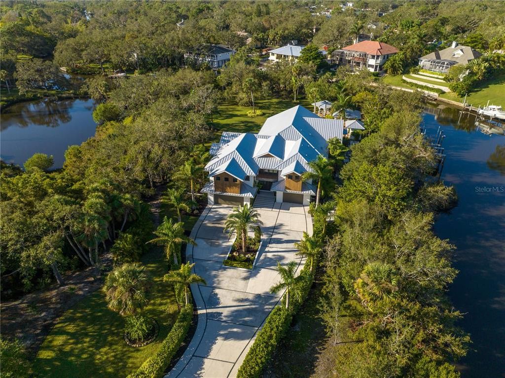 3940 Elysian Woods Lane, Sarasota, Florida is a mature landscaped estate is nestled on 1.47 acres and completely private in a small, gated community with only eight homes, was built with meticulous craftsmanship and bespoke finishes throughout.